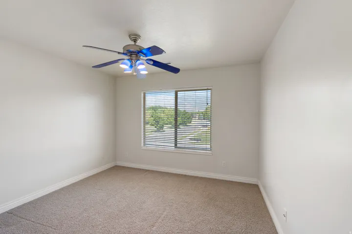 Carpeted flooring with a window featuring horizontal blinds