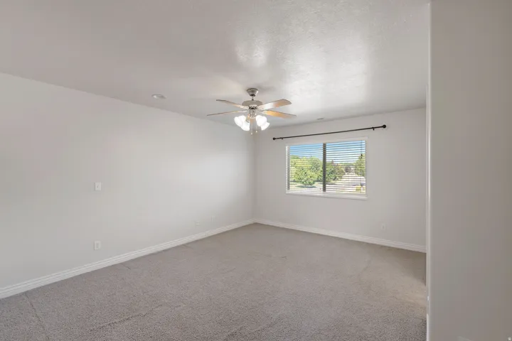 Carpeted flooring, white painted walls, window with blinds, ceiling fan with light fixture, and recessed lighting