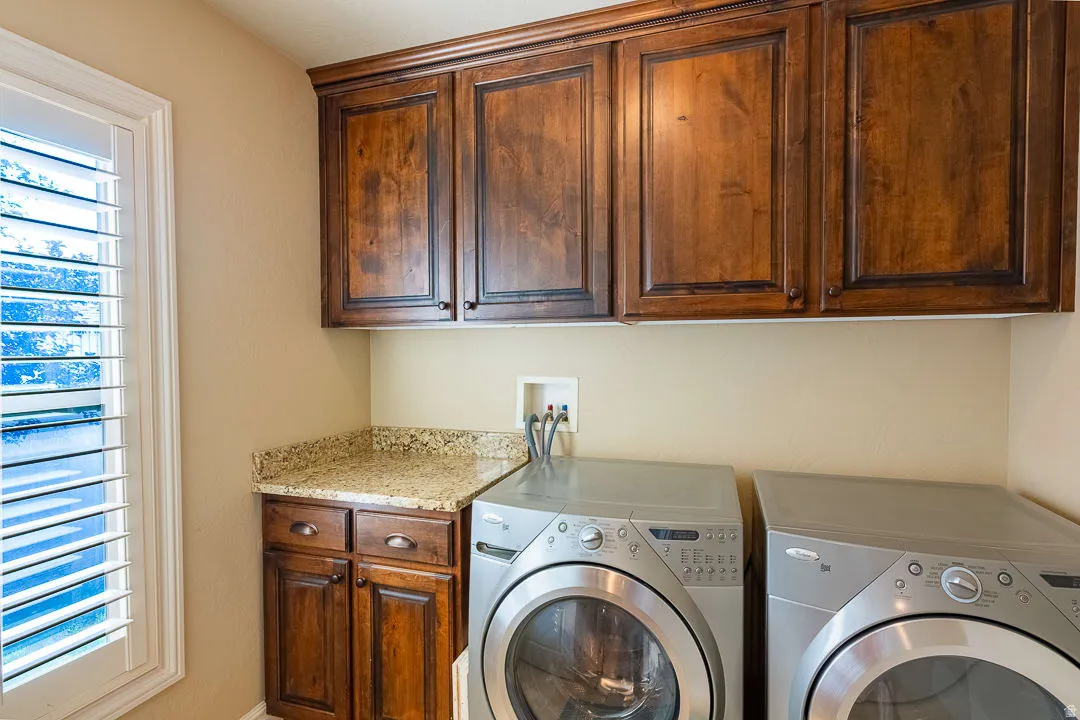 Wood-finish cabinetry, granite-style countertop, and plantation shutters