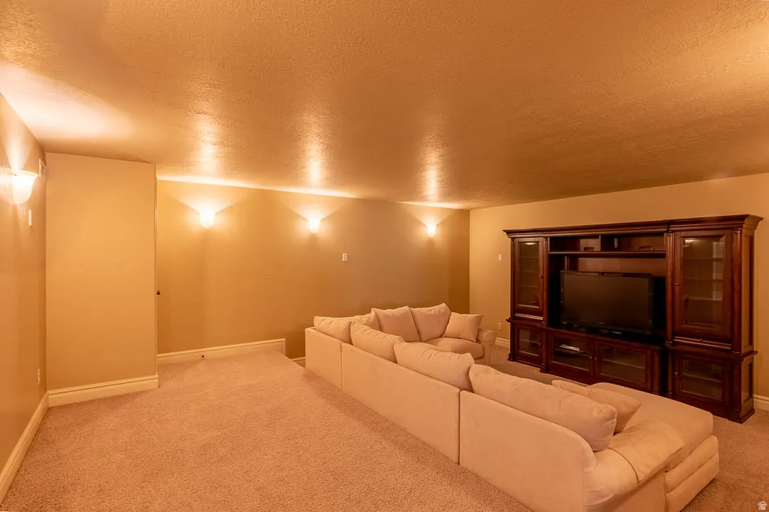 Wall-mounted sconce lighting illuminates the wall space, complemented by neutral wall paint and carpet flooring