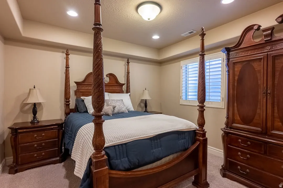Recessed lighting, ceiling-mounted light fixture, crown molding detail, window with plantation shutters, and carpeted flooring