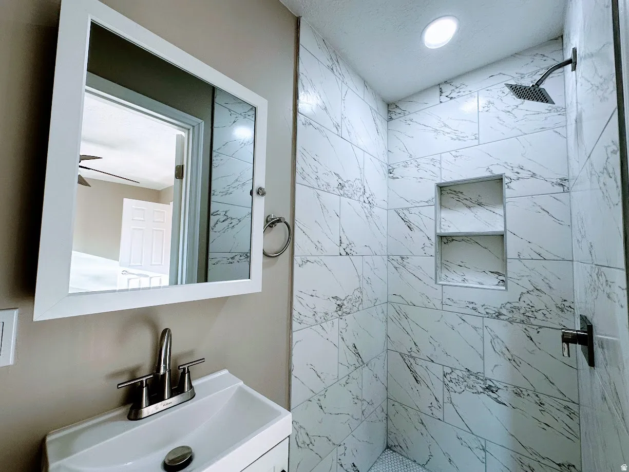 Tiled shower enclosure with built-in shelving and a rain showerhead