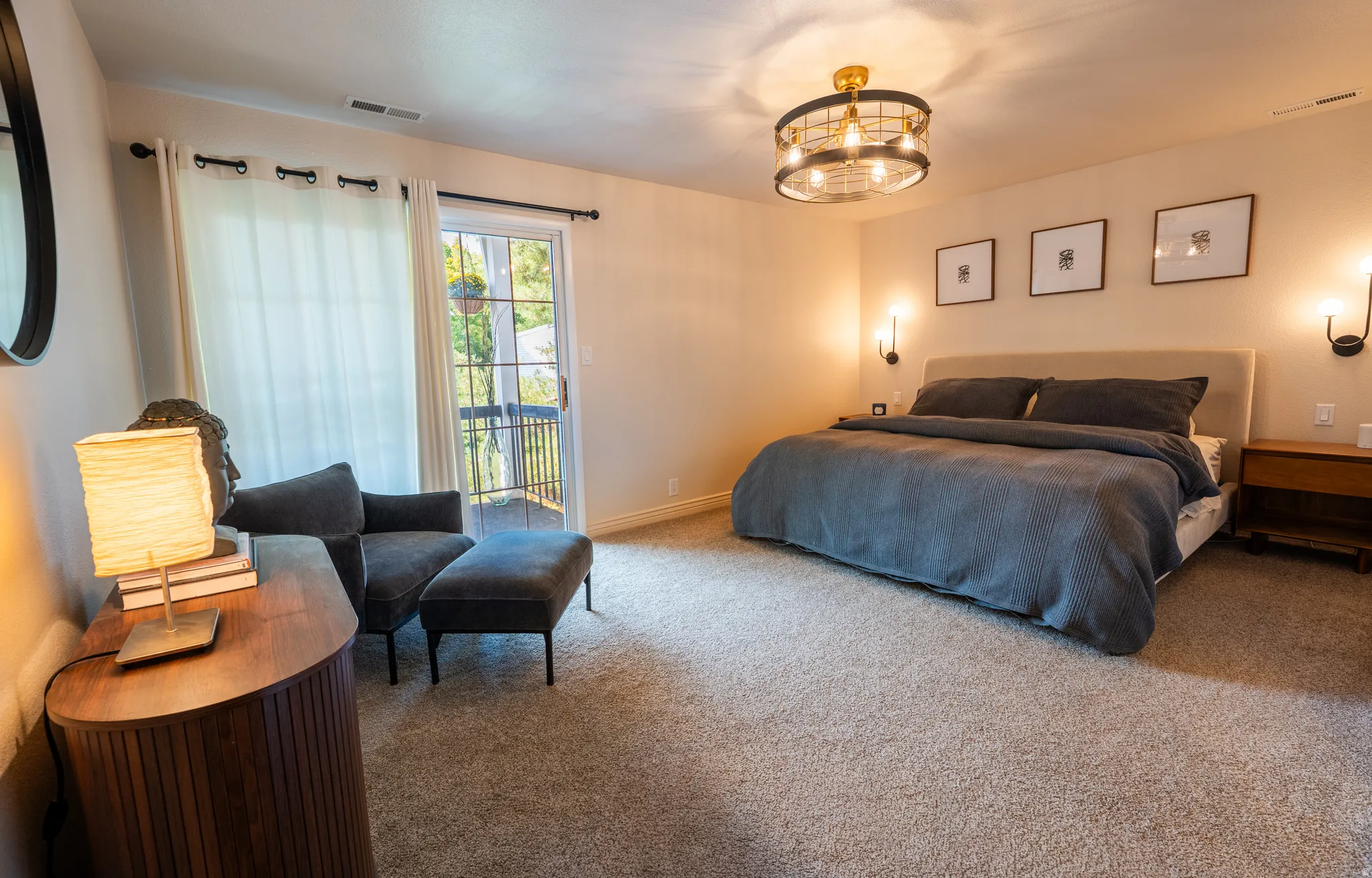Plush carpet flooring, a built-in upholstered headboard, and dual wall sconces