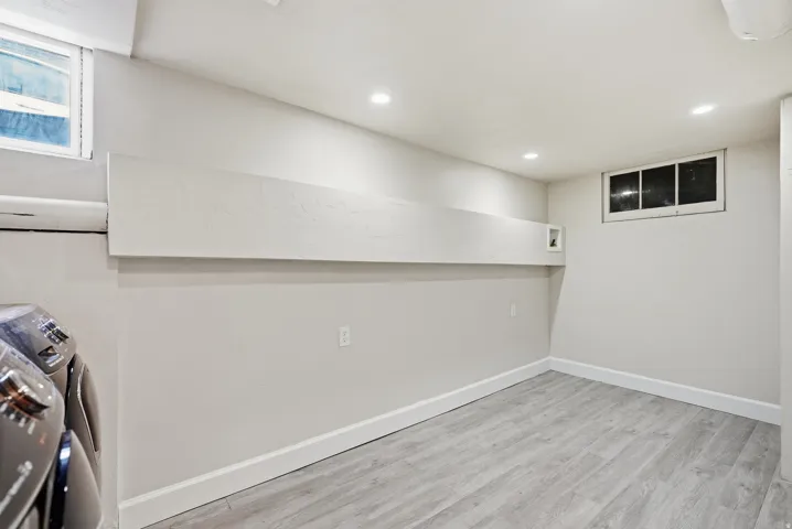 Recessed lighting, wood-finish flooring, and white trim