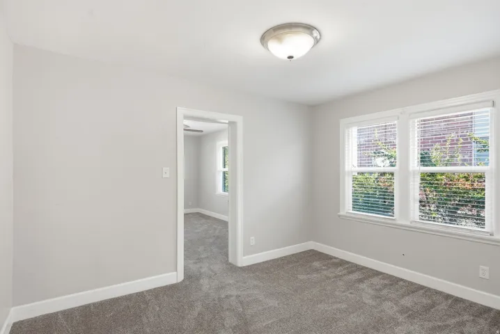 Wall-to-wall carpeting, dual windows with blinds, and neutral wall paint