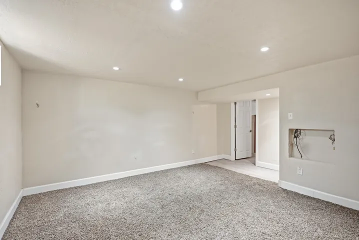 Recessed ceiling lighting, light gray wall paint, and gray carpet flooring