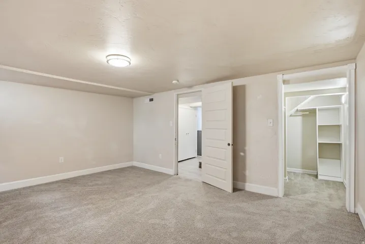 Carpeted room with recessed lighting and a sliding barn door
