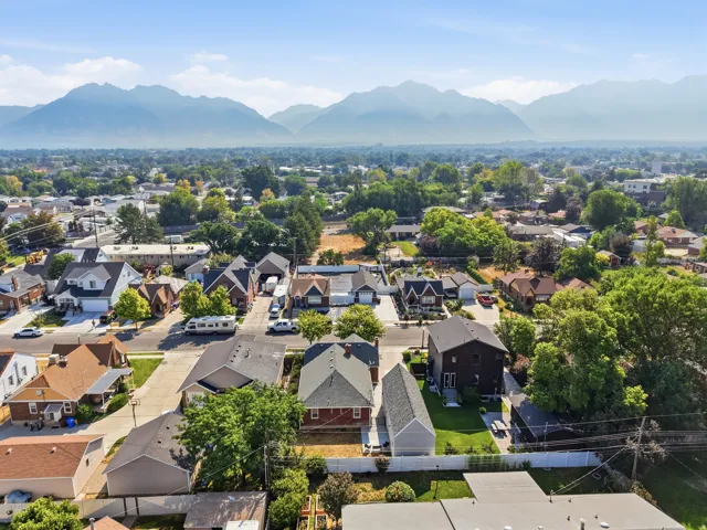 Residential neighborhood with mature trees, established properties, and distant mountain backdrop