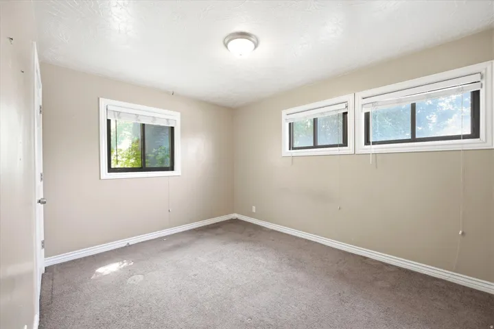 Neutral wall finishes, recessed windows, textured ceiling, and a flush-mount ceiling light