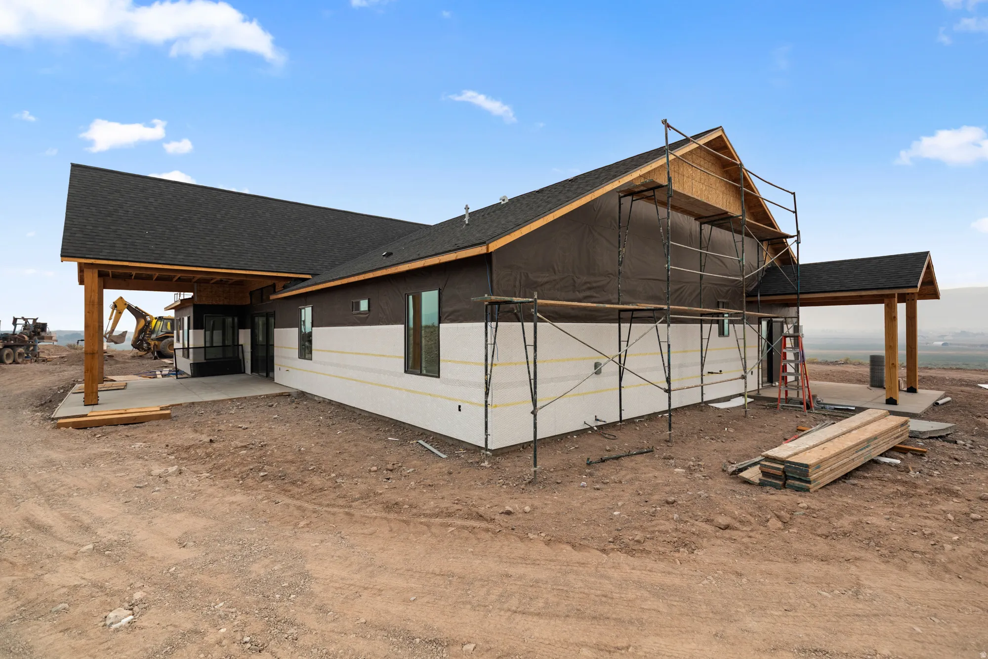 New construction residence featuring a dark shingled roof, exposed wood beams, and multiple covered patio areas