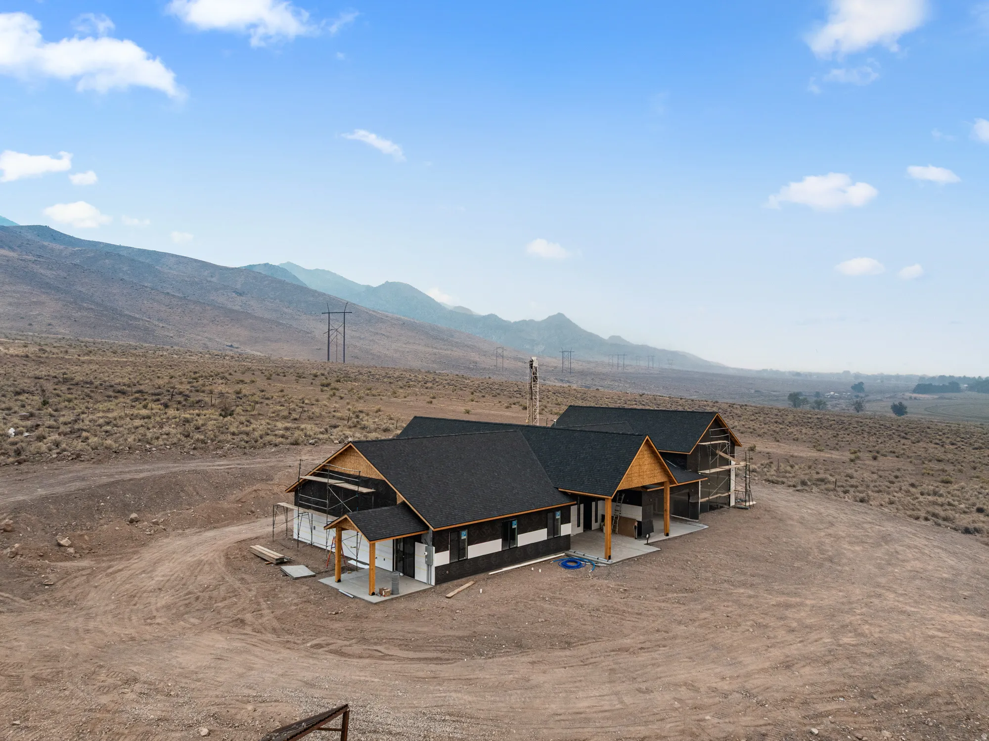 New construction residence featuring a dark shingle roof, wood-clad soffits, and a covered porch