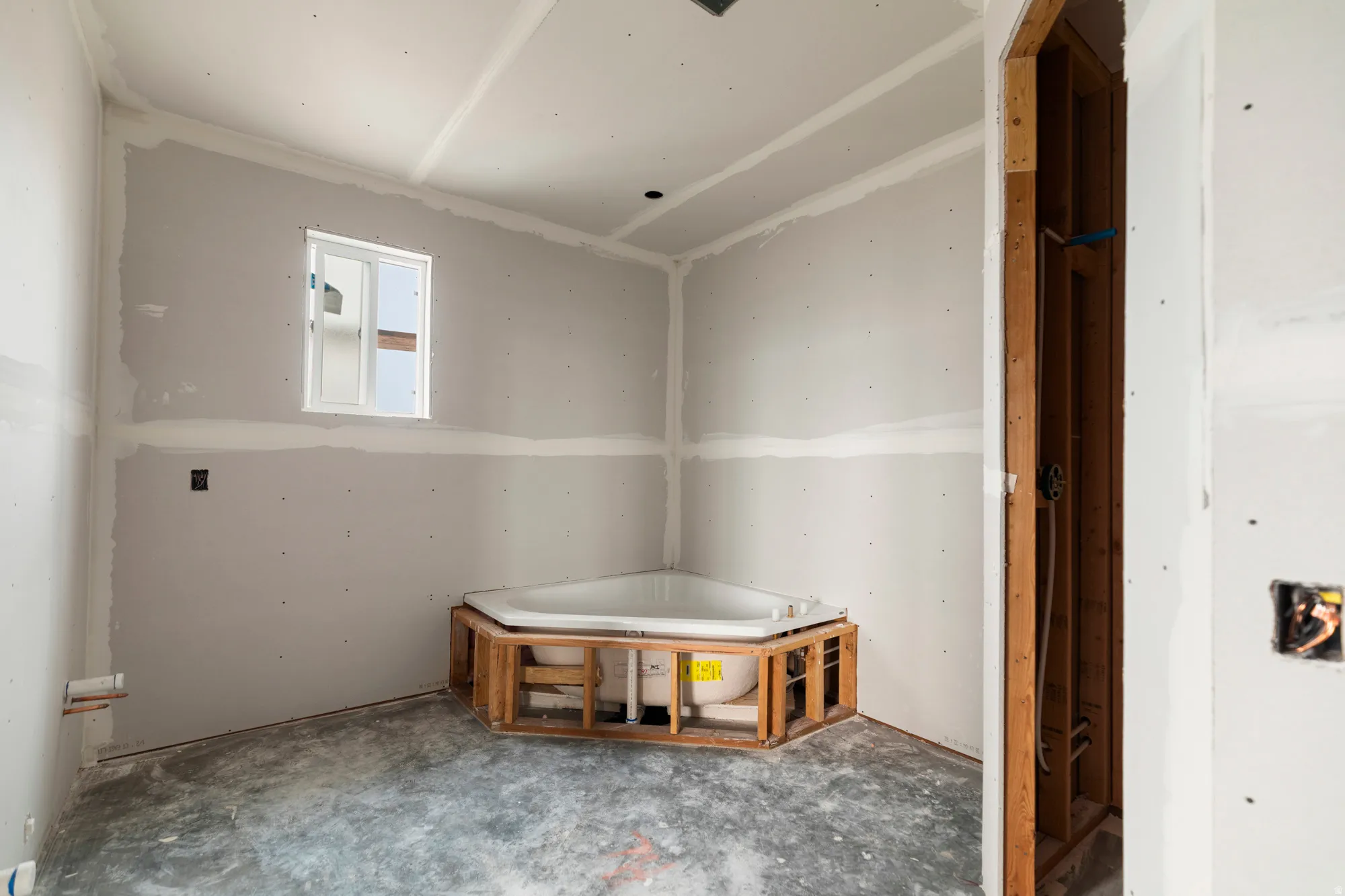 Corner soaking tub with a framed surround and a window