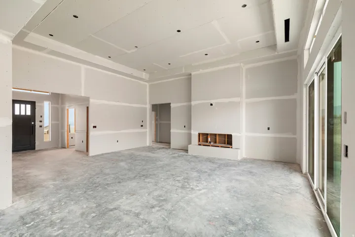 Spacious unfinished interior featuring a tray ceiling, recessed lighting, and a built-in fireplace structure