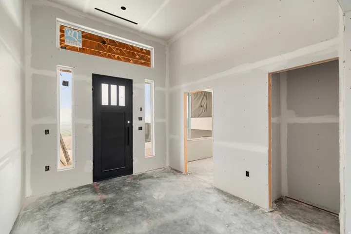 Black entry door with vertical glass inserts, flanked by two vertical windows, and a horizontal transom window above