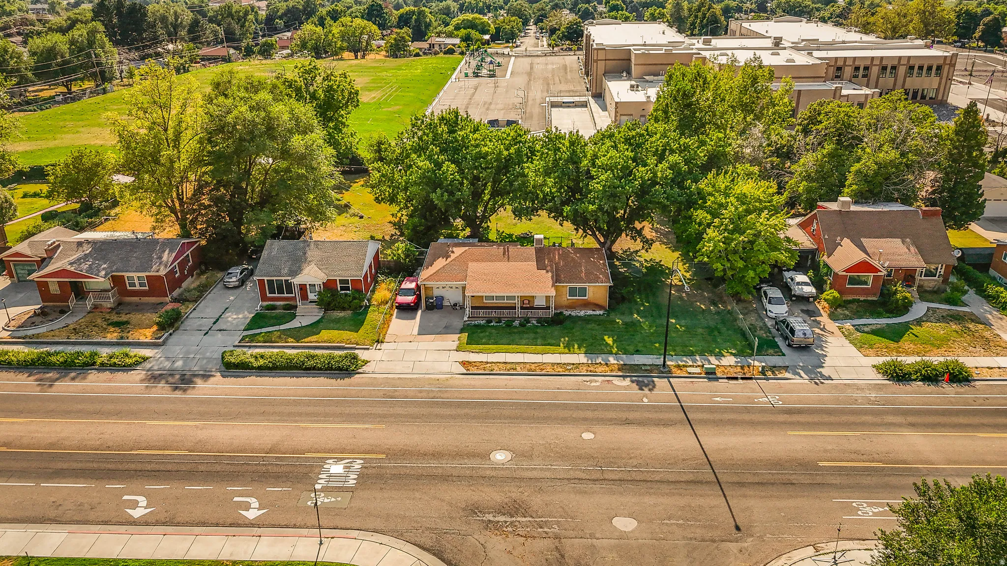 Charming brick homes line this tree-lined street, featuring mature landscaping, manicured lawns, and established greenery
