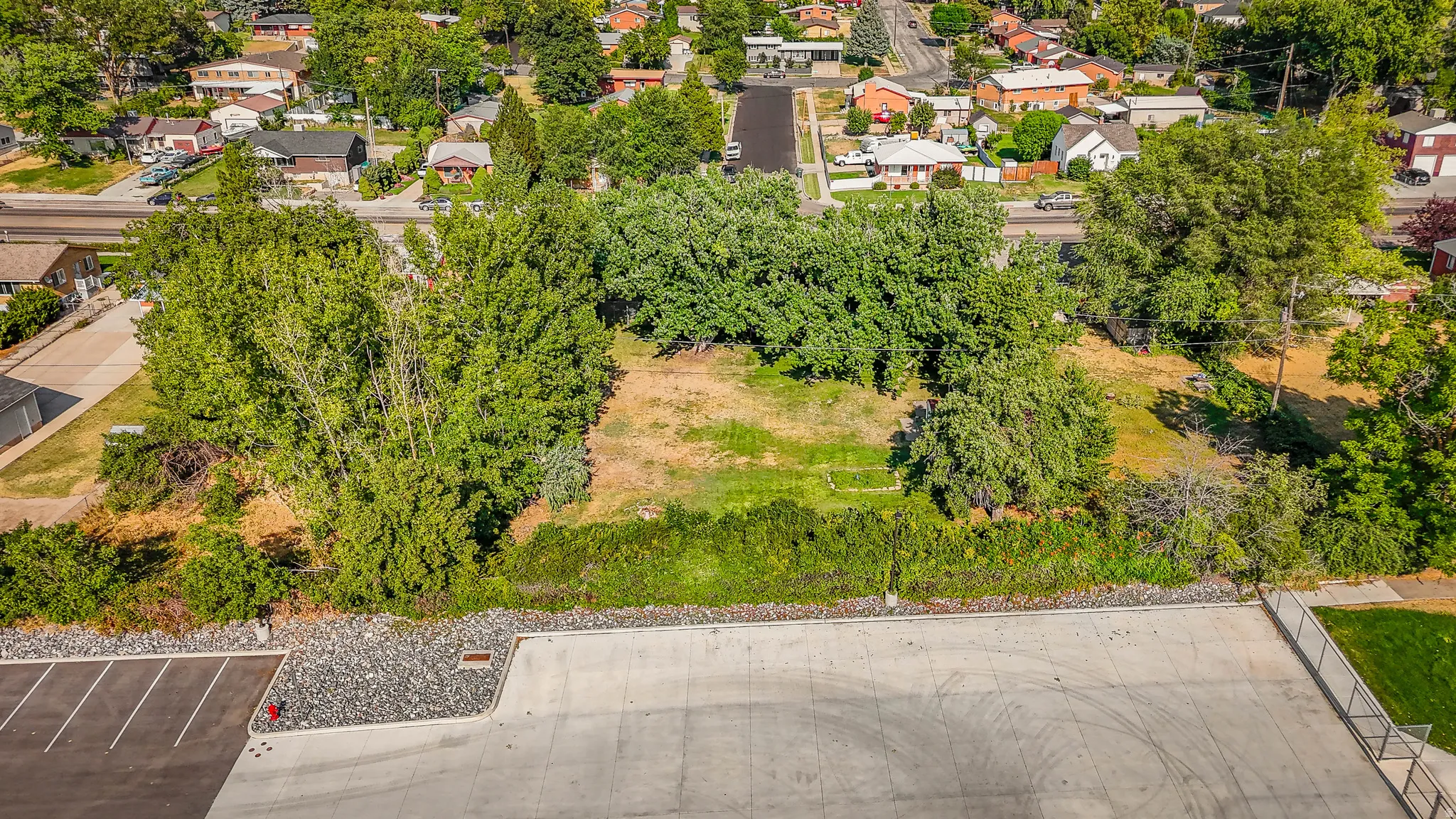 Expansive residential lot featuring mature tree coverage, established landscaping, and a cleared building pad