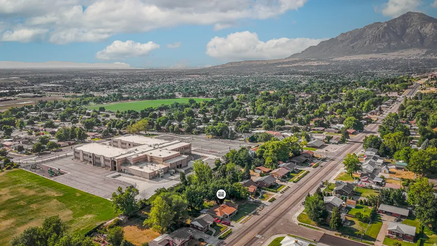Aerial view showcasing a modern commercial/industrial building with clean architectural lines and expansive paved surfaces, situated on substantial acreage