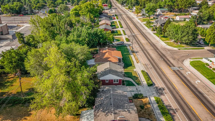 Charming brick residence with a manicured lawn and mature landscaping, situated on a tree-lined lot