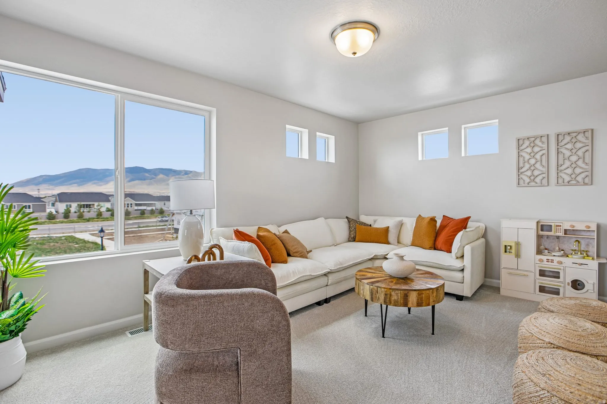 Recessed lighting, multiple windows, plush carpeting, and a rounded semi-flush mount ceiling fixture
