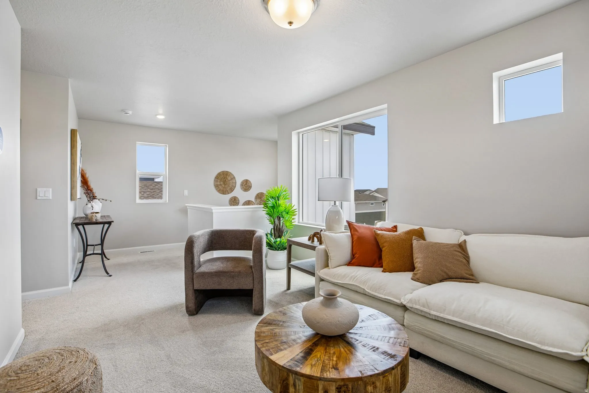 Carpeted flooring, vaulted ceiling, white interior walls, white trim, and multiple windows