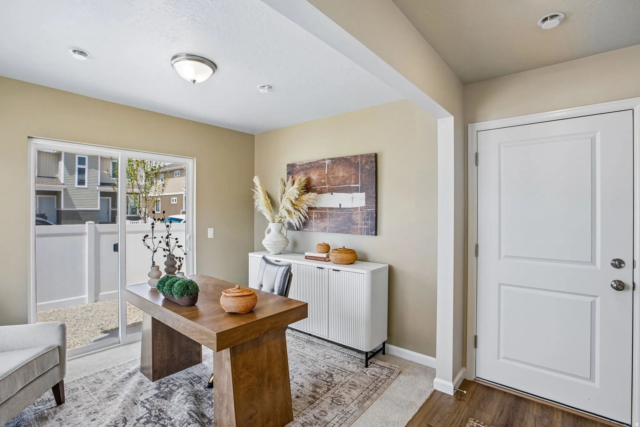 Sliding glass door leading to an outdoor area, recessed lighting, ceiling-mounted light fixture, and paneled entry door