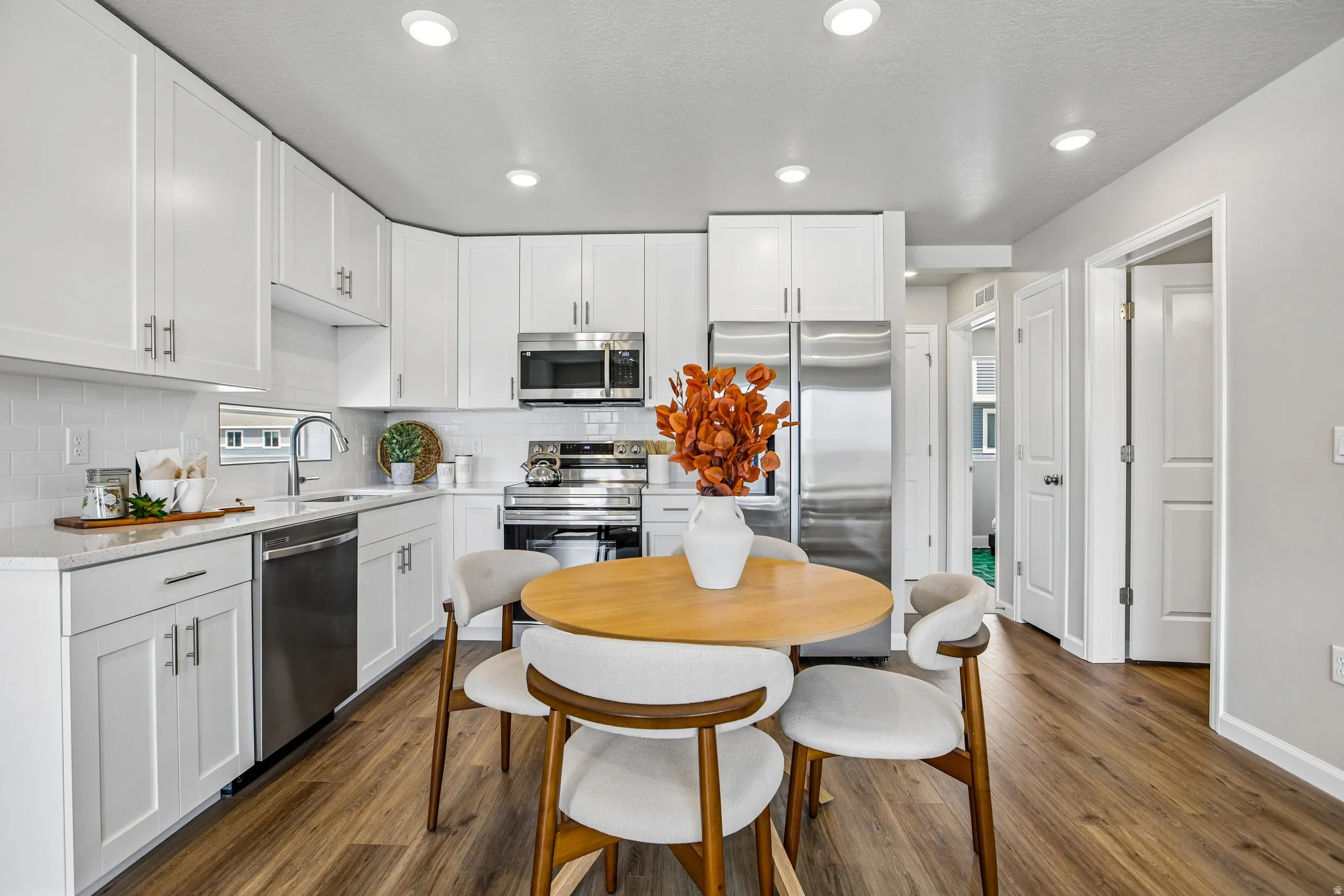 Kitchen featuring white shaker cabinetry, stainless steel appliances, a tile backsplash, and recessed lighting