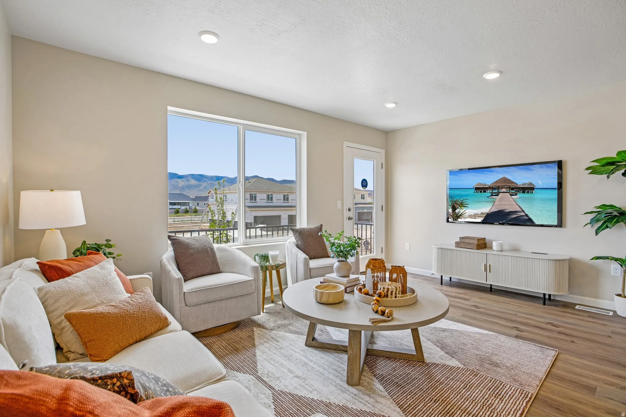 Recessed ceiling lighting, wood-finish flooring, large window, white interior door with glass panel, light-toned walls
