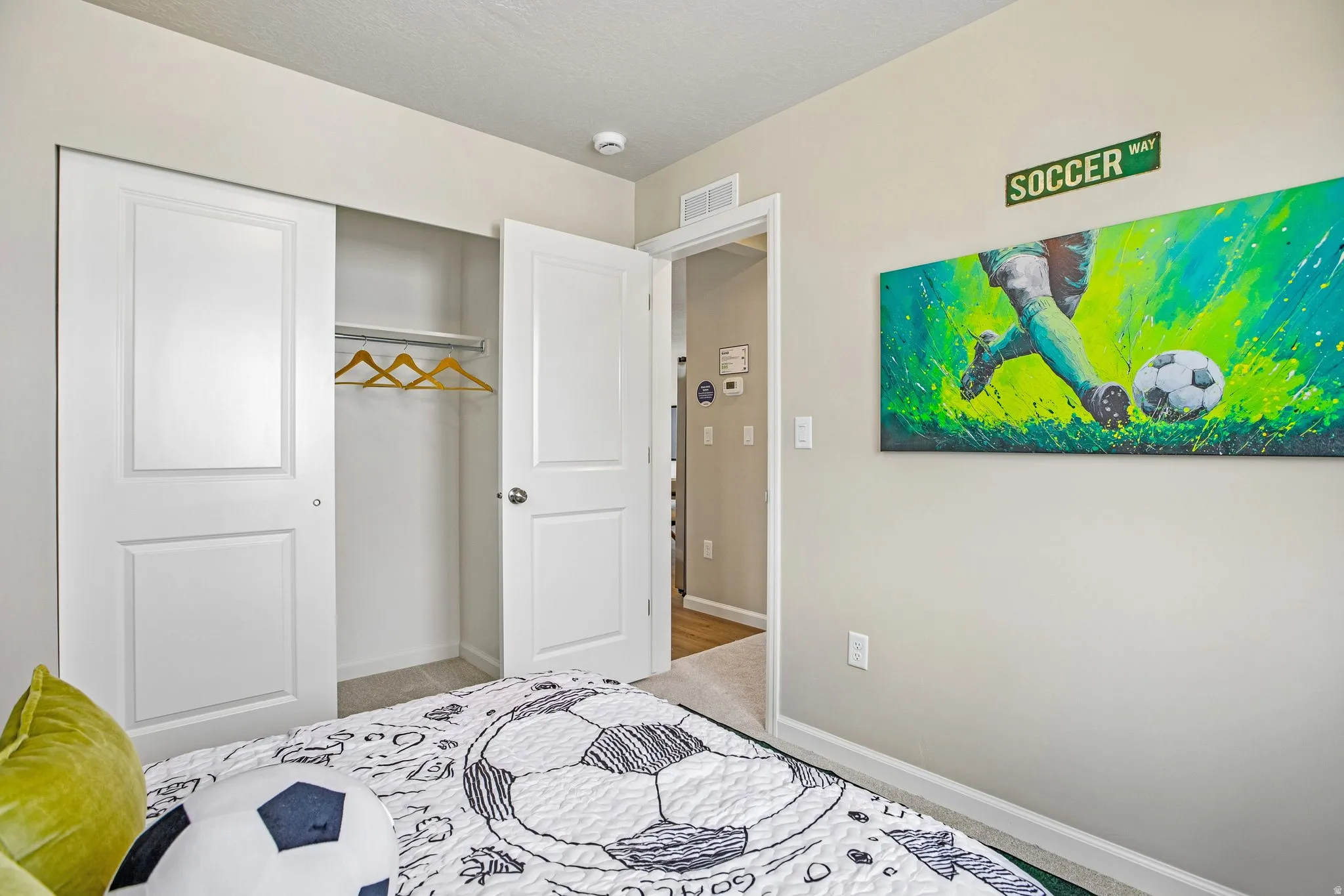 Built-in closet with bifold doors, neutral wall paint, and plush carpeting