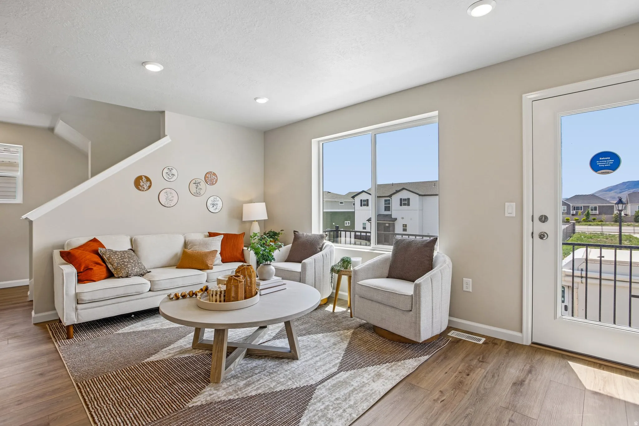 Recessed ceiling lighting, wood-finish flooring, a large window with white trim, and a glass-paneled exterior door