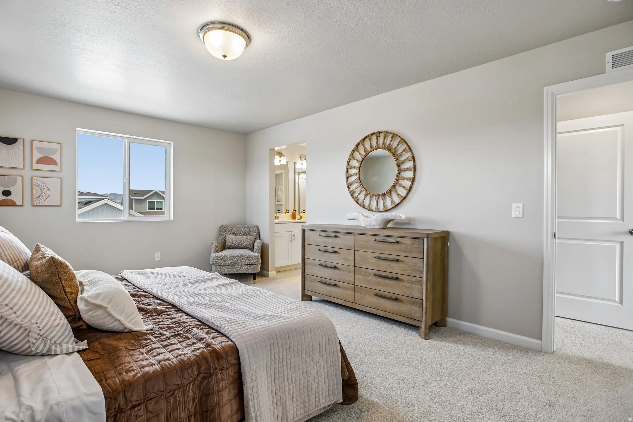 Expansive room with neutral carpeting, a large window, and an overhead light fixture