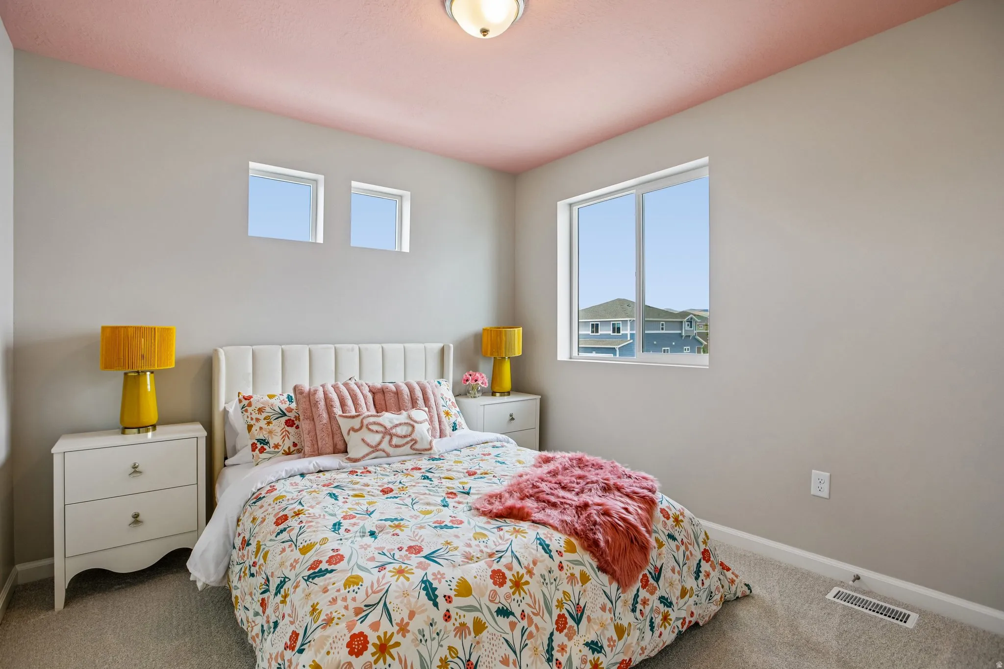 Recessed window placements, large window providing outdoor scenery, neutral wall color, ceiling-mounted light fixture, and textured carpeting