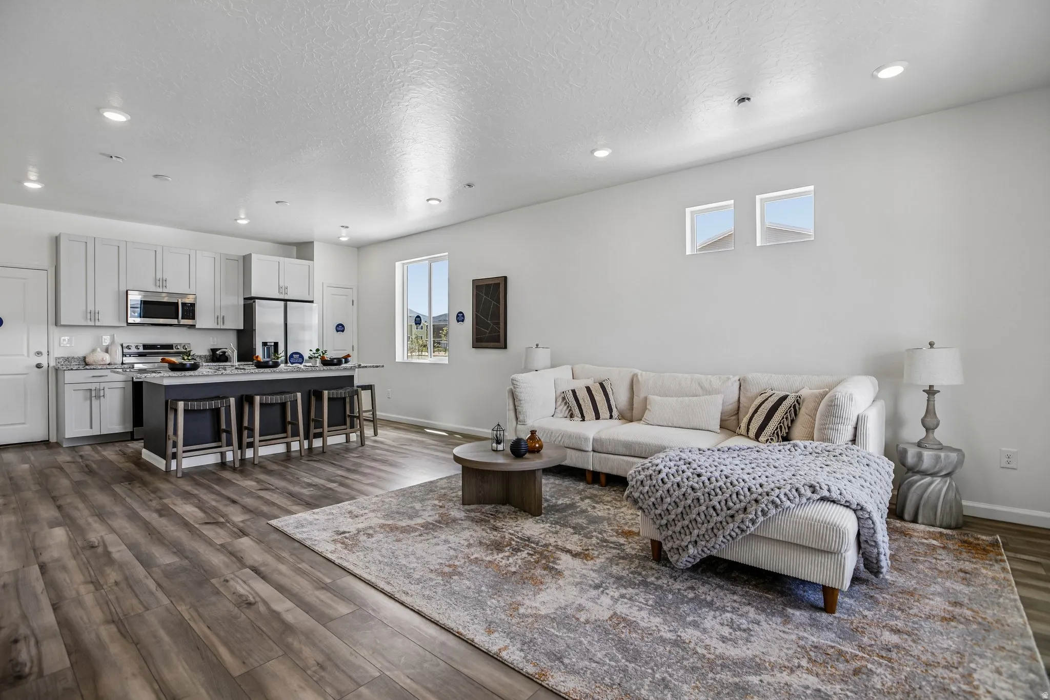 Open-concept living space featuring wood-finish flooring and recessed lighting