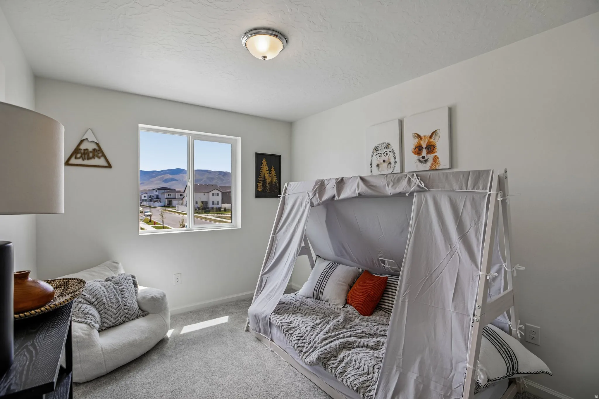 Recessed window with mountain backdrop, textured wall finish, flush mount ceiling light, and wall-to-wall carpeting