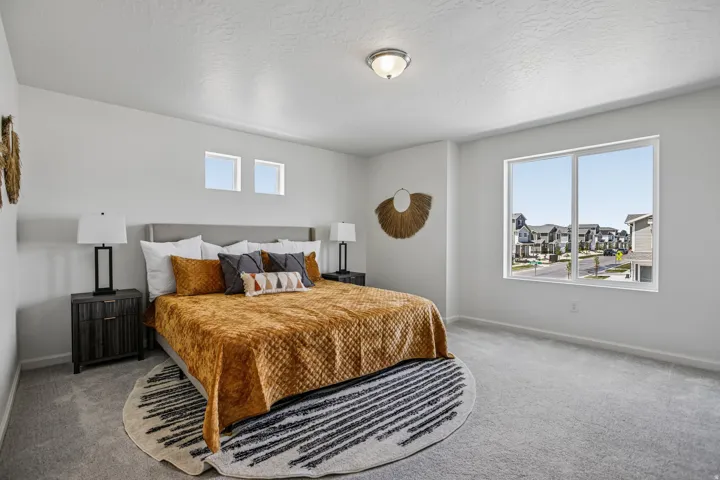 Spacious room featuring light gray carpeting, a large window, two transom windows, and a flush mount ceiling light