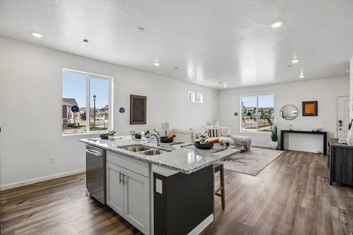 Open-concept living space featuring wood-finish flooring, recessed lighting, and large windows