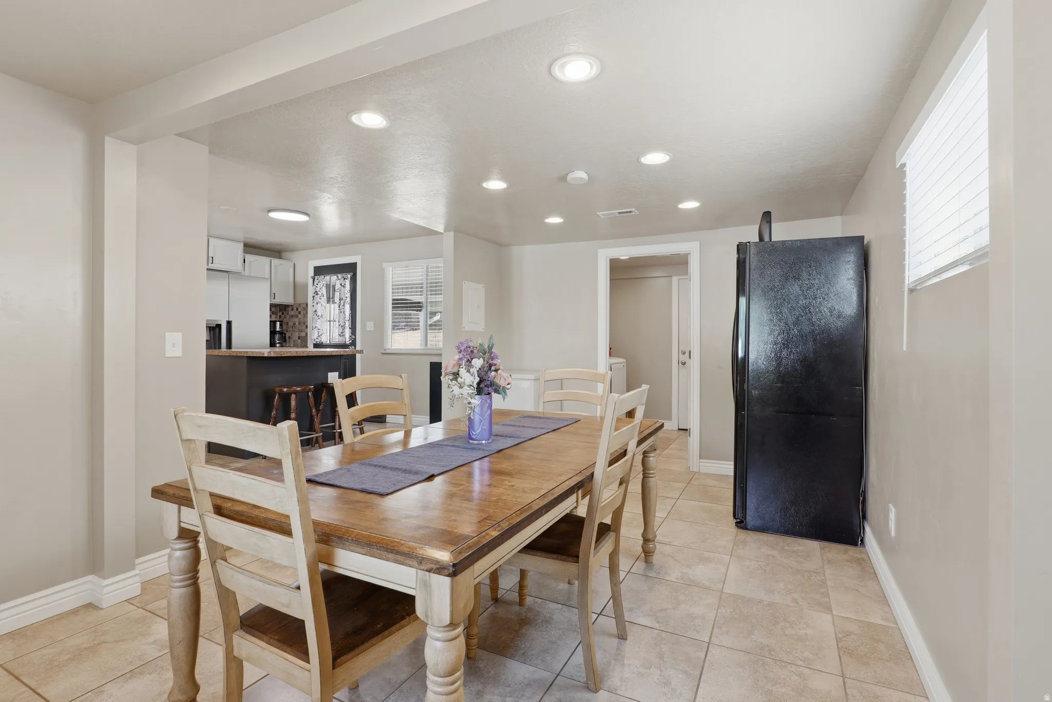 Recessed ceiling lighting, tiled flooring, built-in kitchen island, window with blinds, and white trim