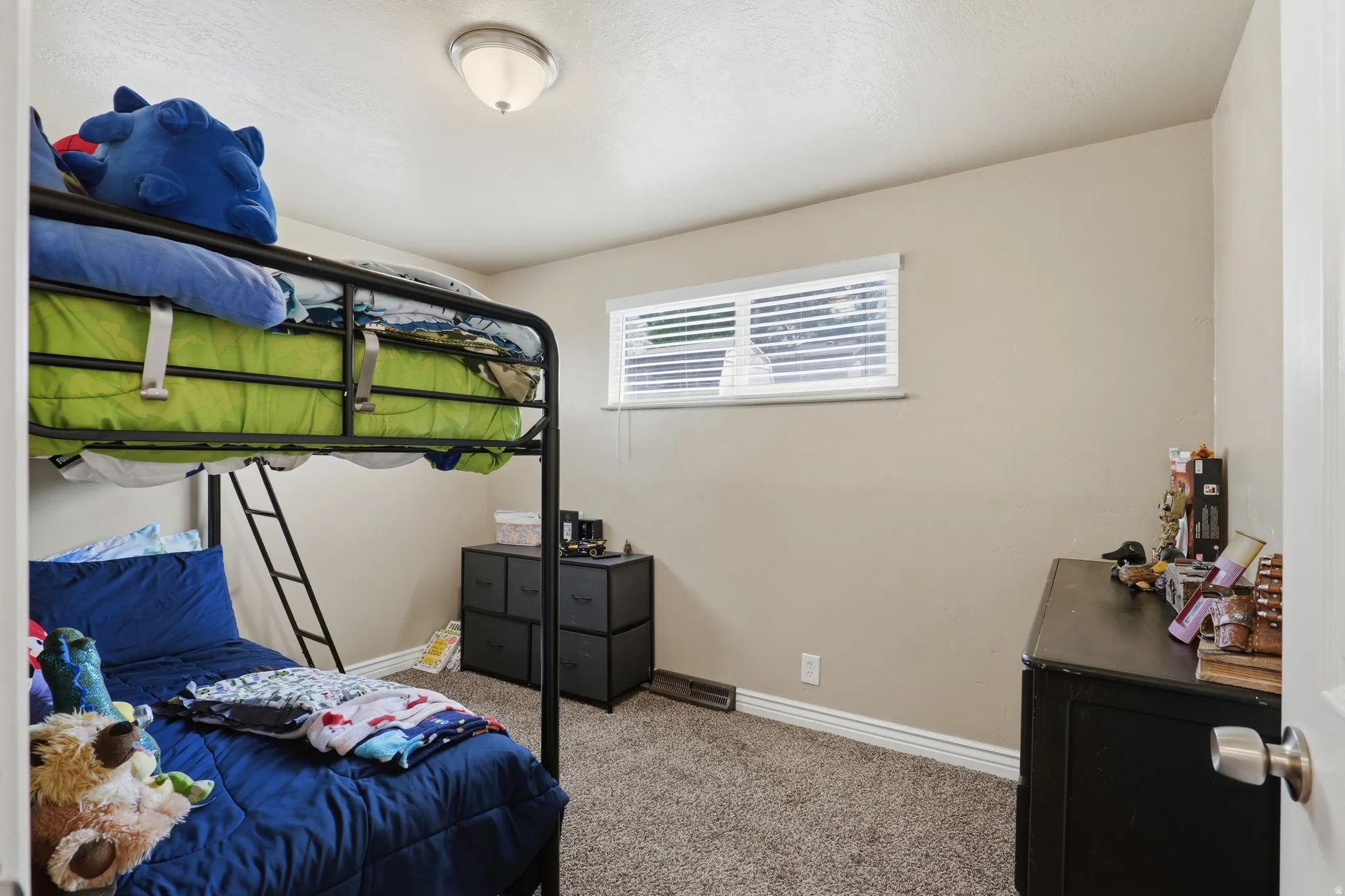 Neutral wall color, carpeted flooring, window with blinds, and flush-mount ceiling light