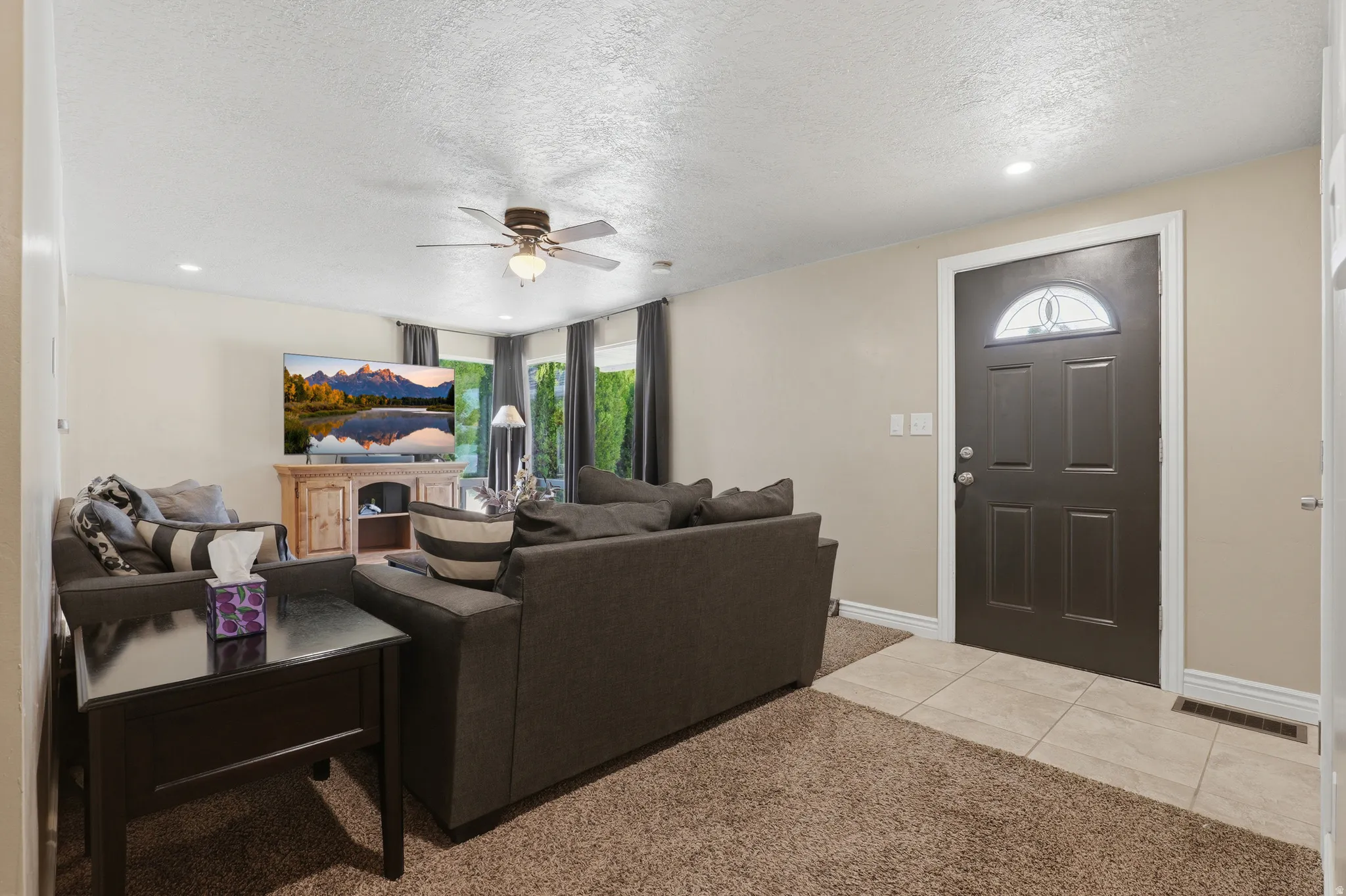 Recessed lighting, ceiling fan, and carpeted flooring in the living area