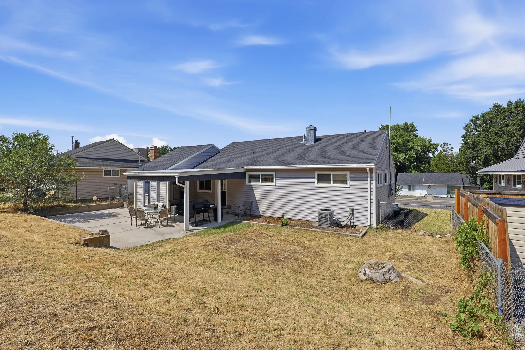 Backyard featuring a covered patio, concrete hardscaping, and a fenced perimeter
