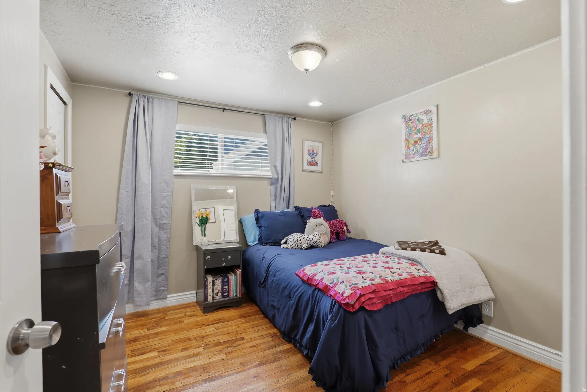 Hardwood flooring, recessed lighting, and a window with blinds