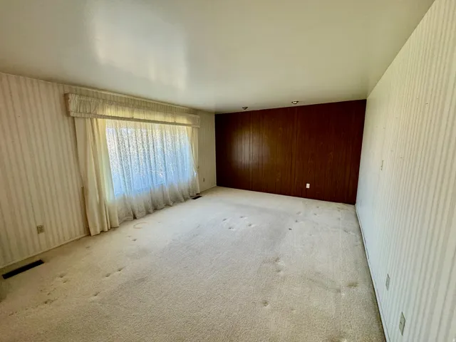 Bright interior space featuring a large window, recessed lighting, and wood paneling