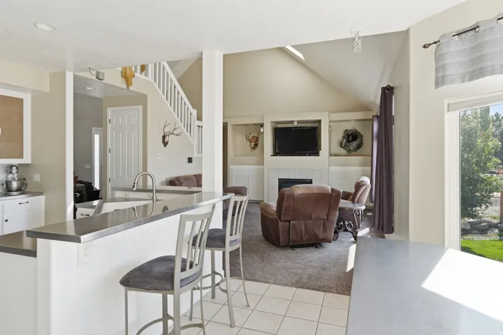 Kitchen island with integrated sink, white cabinetry, and stainless-steel finish countertop