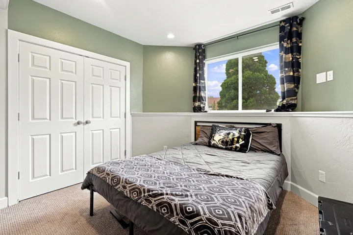 Recessed ceiling lighting, carpeted flooring, white paneled bifold doors, and a large window
