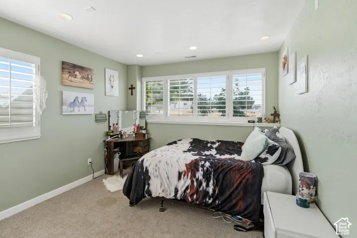 Recessed lighting, multiple windows with white plantation shutters, and textured wall finish