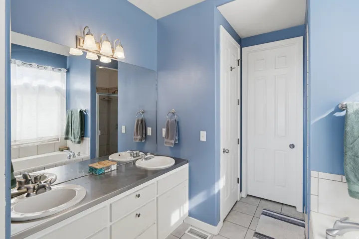 Double vanity with integrated sinks, ample countertop space, and white cabinetry