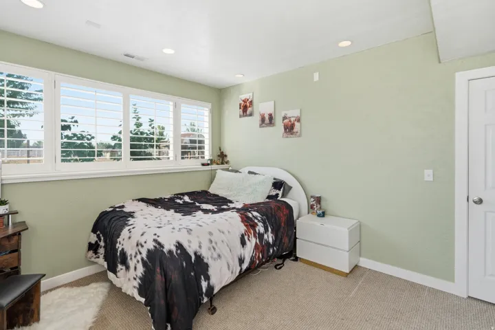 Recessed ceiling lighting, carpeted flooring, white trim, and a white paneled door