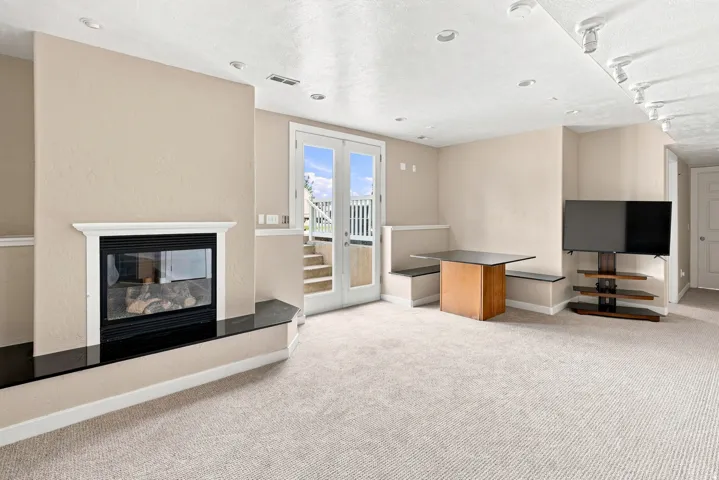 Recessed lighting, built-in fireplace with a dark-toned hearth, built-in bench seating, and French doors