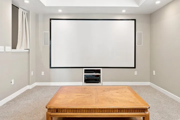 Integrated projection screen with built-in media shelving, recessed lighting, and tray ceiling detail