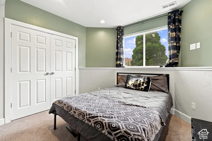 Recessed ceiling lighting, carpeted flooring, white paneled bifold doors, and a large window