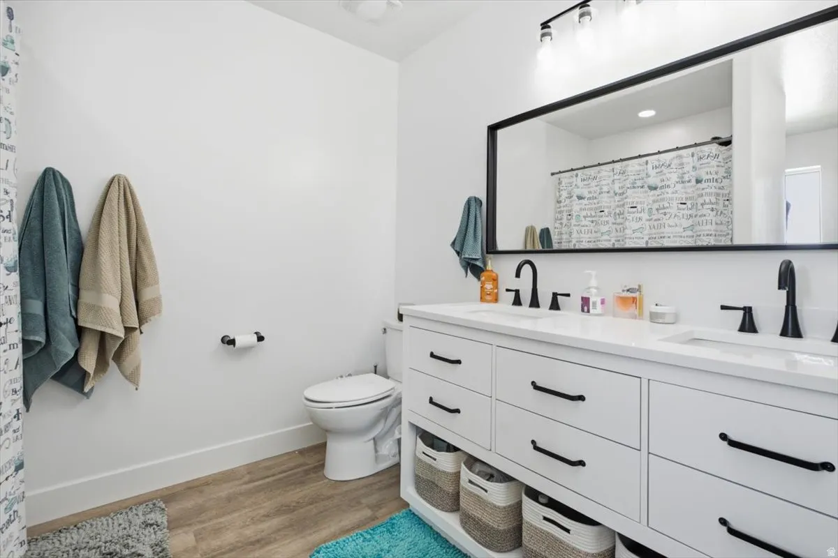 Dual sink vanity with white countertops, matte black faucets, and black framed mirror